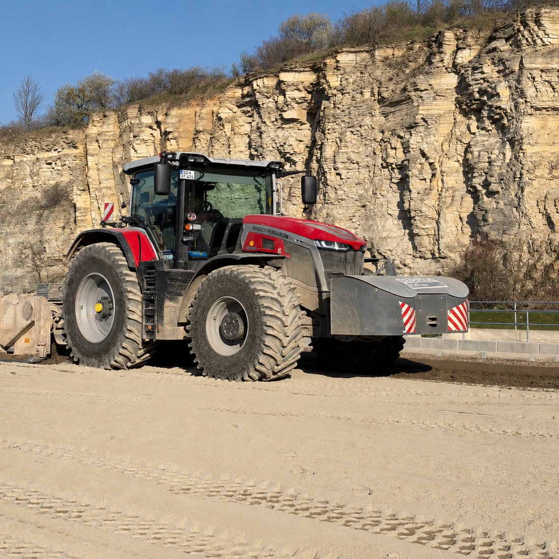 Traktor der Redeker Tiefbau GmbH mit Frontschild bei der Planumsherstellung im Steinbruch