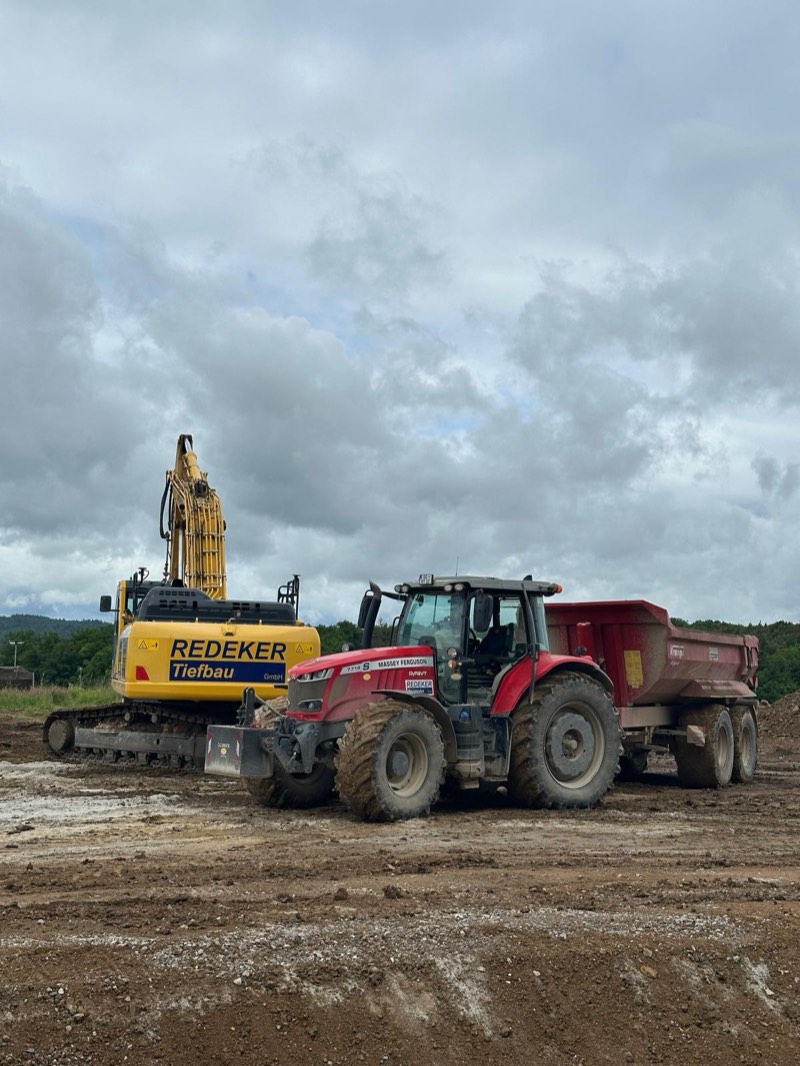 Redeker-Tiefbau-Kettenbagger und Traktor mit Muldenkipper auf der Erdbaustelle